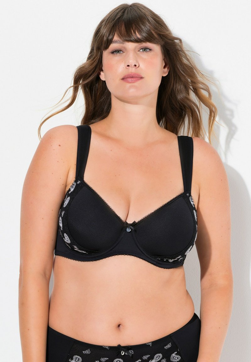 Mustat liivit, joissa on muotoillut kupit, koristeellinen paisley-kuvio sivuilla, säädettävätolkaimet ja pieni nauhadetaili keskellä.