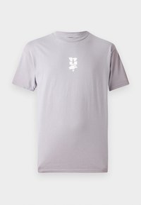 Lys lilla kortærmet t-shirt lavet af blødt bomuld, med et lille hvidt logo trykt på fronten. Klassisk rund halsudskæring.