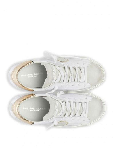 Białe skórzane sneakersy z metalicznymi akcentami w odcieniu złota, okrągły czubek, sznurowana konstrukcja i logo na wkładce. Gumowa podeszwa dla przyczepności.