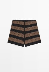 Gehaakte korte broek met afwisselende horizontale zwarte en bruine strepen en een geschulpte zoom op een witte achtergrond.