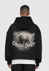 Black hoodie featuring a large graphic design on the back, depicting a serene face with angel wings, titled "Celestial Society" in bold white font.