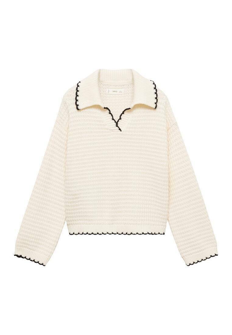 Cremefarvet sweater med struktureret strik, kontrasterende sort scallopkrave og -kant. Har lange ærmer, cropped design og v-hals.