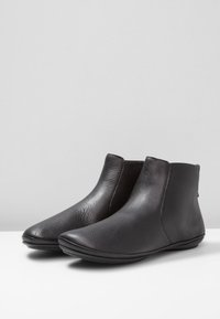 Svarta läder ankle boots med en slät yta, rundade tår och minimalistisk design. Har en flexibel gummisula.