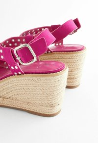Fuchsiové wedge sandále so širokými popruhmi, zdobené kovovými cvokmi a jutu obalenými podrážkami, s striebornou sponou na remienku okolo členku.