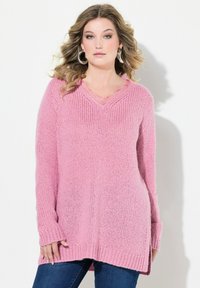 Luźny, różowy sweter z długim rękawem, wykonany na drutach, z dekoltem w kształcie litery V, teksturowanym materiałem i bocznymi rozcięciami u dołu. Dodatkowo sweter posiada ściągacze przy mankietach.