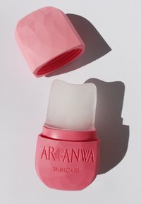 Contenitore per skincare rosa con superficie testurizzata, dotato di un coperchio rimovibile e di un compartimento interno traslucido con parte superiore curvata.