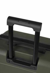 Valigia rigida color oliva con superficie strutturata, dotata di maniglia nera retrattile e chiusura con cerniera nella parte superiore.