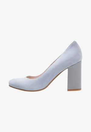 Escarpin en daim bleu clair à talon haut avec un bout arrondi et un talon bloc gris uni. Texture lisse, design minimaliste, silhouette classique.