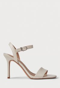 Beige høyhælte sandaler med glatt lærfinish, åpen tå, bred frontstropp og justerbar ankelstropp med metallspenne.