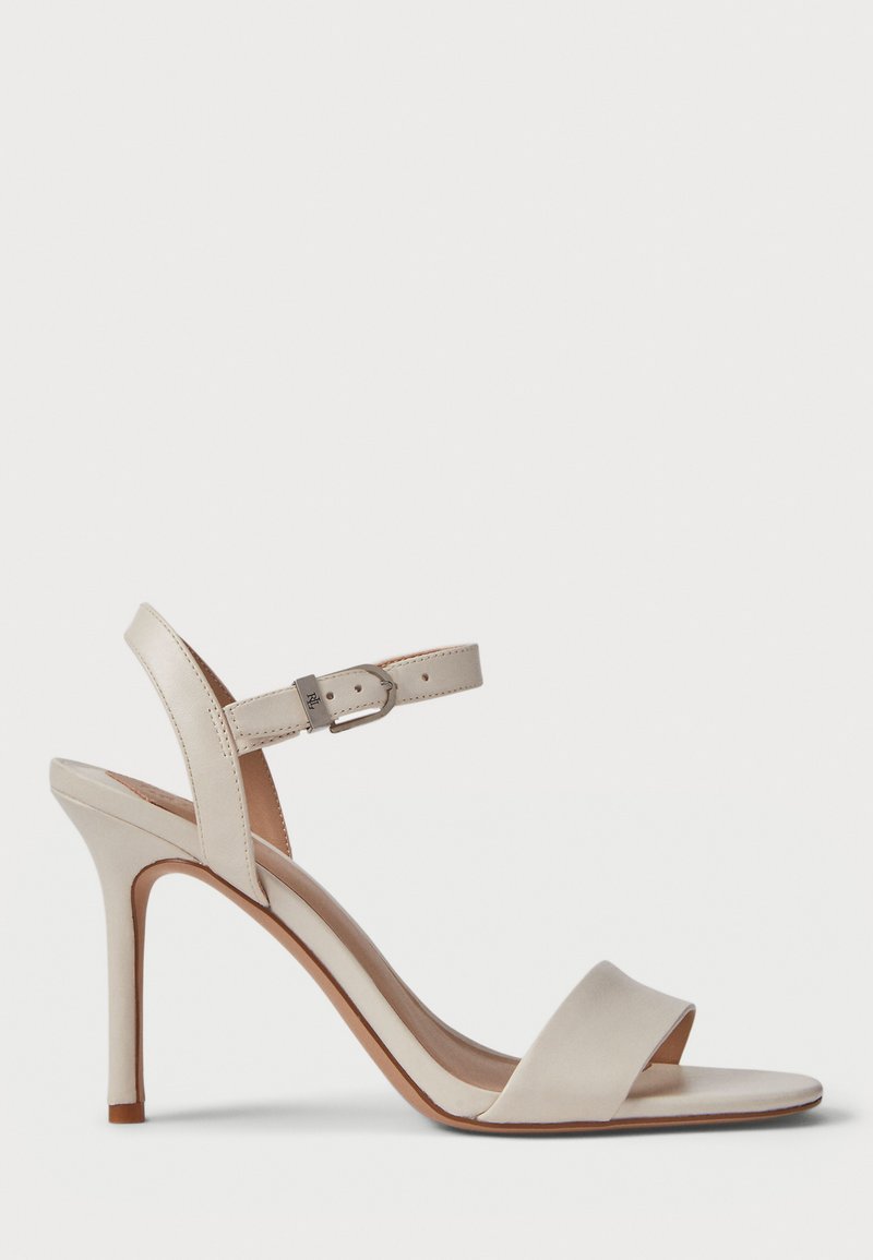 Beige høyhælte sandaler med glatt lærfinish, åpen tå, bred frontstropp og justerbar ankelstropp med metallspenne.