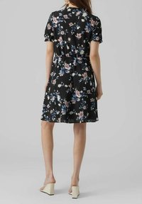 Vestito floreale in tessuto nero, con maniche corte, vita elasticizzata e taglio al ginocchio con motivi floreali pastello e tessuto morbido.