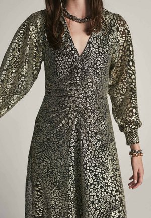 Šaty s leopardím potiskem v černé a kovově zlaté barvě, dlouhými objemnými rukávy, výstřihem do V a nařaseným detailem v pase. Elegantní a strukturovaná látka.