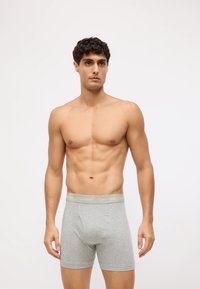 Sivi pamučni bokserice s mekim elastičnim pojasom s oznakom "Calvin Klein", s uskim fitom i glatkom teksturom.