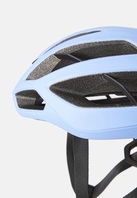 Jasnoniebieski kask rowerowy o aerodynamicznym kształcie, z wieloma otworami wentylacyjnymi, teksturowanym czarnym wnętrzem oraz regulowanymi czarnymi paskami.