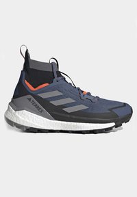 Herren-Freizeitschuh mit einem Obermaterial aus grauem und marineblauem Textil, schwarzen Akzenten, orangefarbenen Details und einer gepolsterten weißen Sohle. Verfügt über einen hohen Schaft.