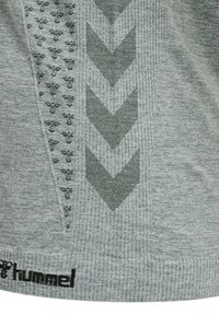 Szary sportowy shirt z fakturowanej tkaniny, wzorami zygzakowymi oraz logo na krawędzi. Widoczne chevronowe detale w ciemniejszym odcieniu szarości.