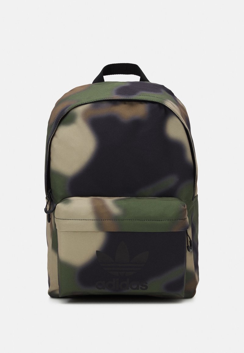 Adidas ryggsäck med kamouflage-mönster, framficka med dragkedja och svart handtag mot en vit bakgrund.