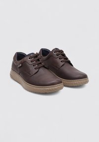 Chaussures en cuir brun avec une finition lisse, bout rond, design à lacets et semelle en caoutchouc texturée. Présente des accents de couture subtils.