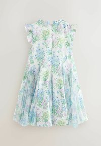 Vestito bianco plissettato con stampa floreale in tonalità pastello di azzurro, viola e verde, con maniche a sbuffo arricciate, disteso su uno sfondo chiaro.