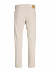 Pantalon beige coupe droite avec deux poches arrière et un écusson de marque marron sur la ceinture, vu de dos.