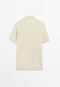 Poloshirt met korte mouwen in lichtbeige, gemaakt van een gladde stof. Kenmerkt zich door een klassieke kraag en een nette snit met een minimalistisch ontwerp.