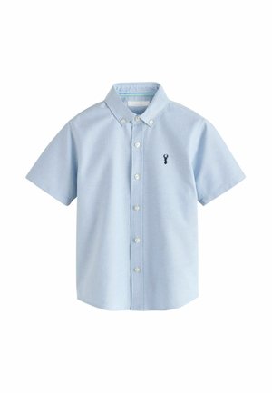 Light blue short-sleeve button-up shirt with a button-down collar and small dark emblem on the left chest.