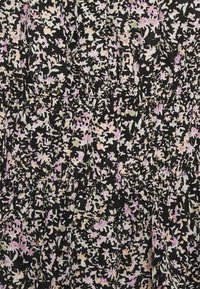 Svart tygklänning med ett blommönster som visar rosa och krämfärgade blommor. Texturerade smockdetaljer vid midjan ger definition.