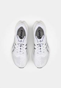 White athletic shoes with mesh upper, perforated details, and black stripe accents. Rounded sole and lace-up design for secure fit.