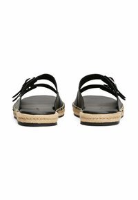Sandales en cuir noir avec une semelle en jute tressé. Design ouvert, avec deux brides ornées d'un nœud à l'avant. Texture lisse.