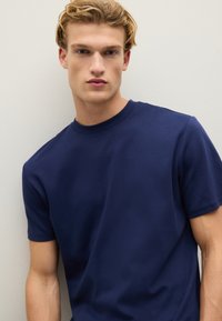 T-shirt di cotone blu navy con collo rotondo e maniche corte, caratterizzata da una texture liscia e una vestibilità comoda.