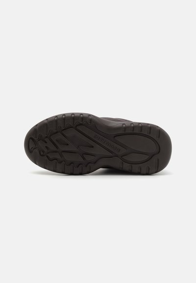 Black sports shoe sole with textured rubber and distinct tread pattern. Features grooves for traction and flexibility. No visible accents.