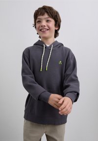 Gray hoodie with a kangaroo pocket, adjustable drawstrings in contrasting colors, and a small green skull logo on the chest.