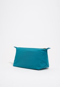 Bolsa de tela en color verde azulado con forma rectangular, cierre de cremallera y dos pequeñas asas laterales. Textura suave, diseño minimalista, sin patrones visibles.
