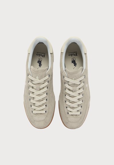Paire de baskets en daim beige clair avec des lacets blancs, vue de dessus. Logo Polo Ralph Lauren imprimé à l'intérieur de chaque chaussure.