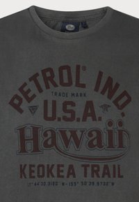Šedé bavlnené tričko s červeným a modrým textom: "PETROL INO. U.S.A. Hawaii Keokea Trail" s geografickými súradnicami nižšie.