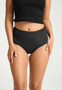 Culottes de bain noires taille haute avec un matériau lisse et extensible ; présente des détails en panneaux et une finition sans couture pour un confort optimal et un ajustement parfait.