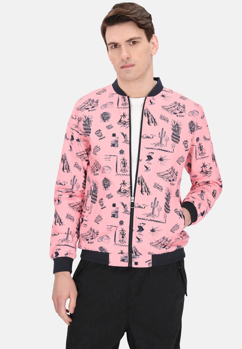 Roze bomberjack met zwarte tropische grafische afbeeldingen, geribbelde manchetten en zoom, en een ritssluiting aan de voorkant. Draagt over een wit shirt.