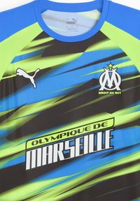 Sort, blå og neon grøn atletisk trøje. Har Puma-logo, tekst "Olympique de Marseille" og dynamiske grafiske mønstre. Korte ærmer.