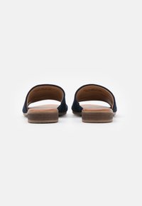 Námořnické semišové klouzavé sandály s otevřenou patou, dřevěnými blokovými podpatky a hladkými koženými stélkami. Minimalistický design bez dalších akcentů.