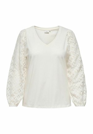 Valkoinen V-pääntie, jossa on teksturoidut pitsiset pörhelöhihat, sileä vartalo ja joustavat hihansuut, korostaen monimutkaisia geometrisia kuvioita.