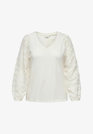 Vit V-ringad topp med texturerade puffärmar i spets, med en slät överdel och elastiska mudd, som framhäver intrikata geometriska mönster.