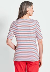 Kurzärmeliges gestreiftes T-Shirt mit roten, blauen und weißen horizontalen Linien. Weicher Stoff, runder Halsausschnitt und reguläre Passform.