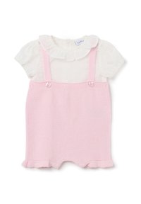 Mono de punto rosa con tirantes y acentos de botones, que presenta una blusa blanca de manga corta con un cuello con volantes y lunares.
