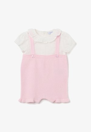 Romper en tricot rose avec bretelles et accents de boutons, accompagné d'un blouse blanche à manches courtes avec un col volanté et des pois.