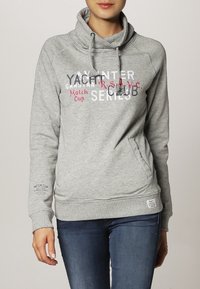 Maglione grigio con collo a barco, caratterizzato da stampe testuali in rosso e bianco, tasche laterali e polsini e orlo a coste.