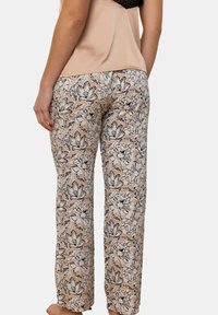 Pantalons de pyjama légers à motifs floraux en beige avec des fleurs noires et blanches ; coupe ample, taille élastique, texture lisse.