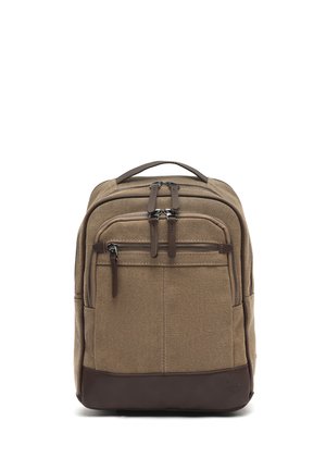 Mochila de lona marrón con múltiples compartimentos con cremallera y base de cuero, mostrada en posición vertical con el asa visible en la parte superior.