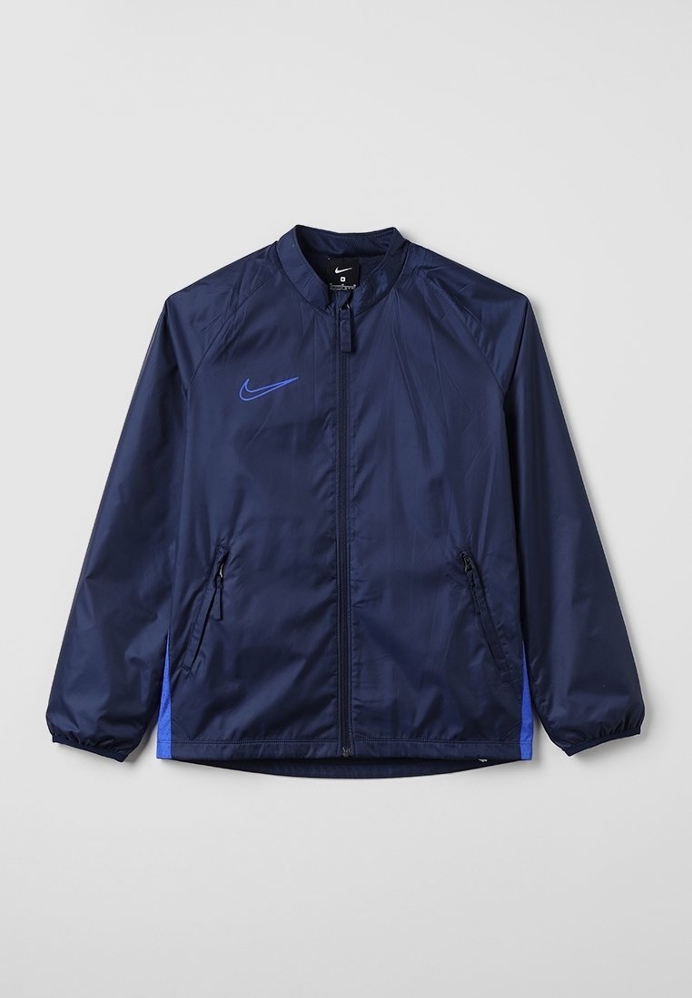 Navy blue windbreaker jacket with a zip front, stand collar, side pockets, and a blue Nike logo on the chest. Smooth, lightweight material.