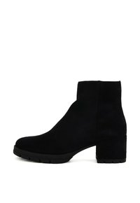Stivale alla caviglia in suede nero con tacco spesso, superficie liscia, punta arrotondata e design minimalista senza hardware o dettagli visibili.