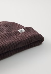 Pleteni bordo zec sa rebrastom teksturom i preklopom. Ima izvezeni logotip na bijelom oznaku.